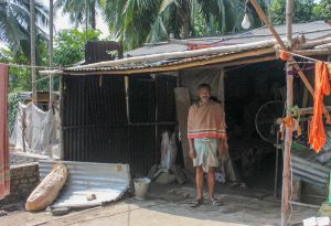 Paresh in front of his tarpaulin shed