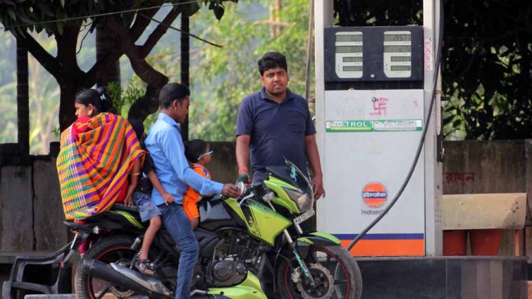 A pump worker refueling a bike with its riders appearing without helmet. Picture by Abhi Ghosh