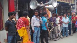 Businessmen persuading crowd using loudspeakers,