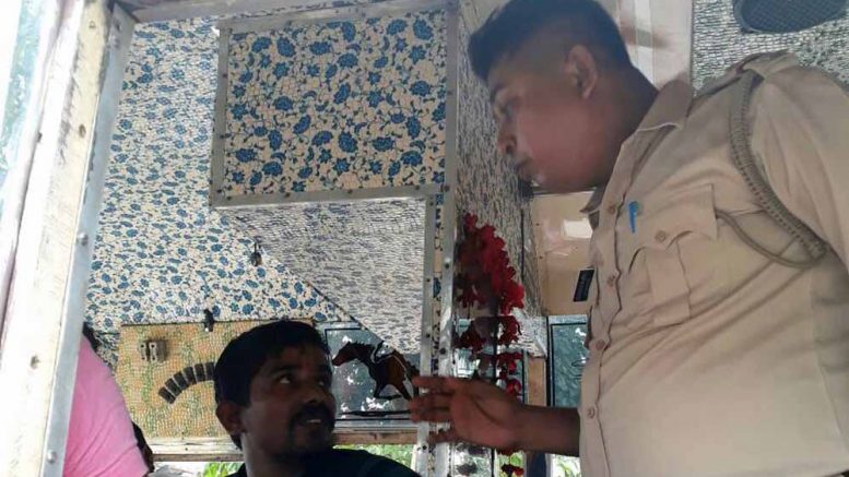 A Police official talking to a passenger in bus of Krishnanagar-Karimpur route.