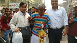An elderly vagrant in a new attire with Santipur police OC Raja Sarkar (left)