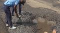 A civic volunteer repairs the road in Govindapur of Santipur