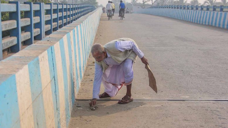 Rajkumar Pal cleaning the road over the Jugal Kishore Bridge